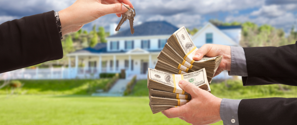 Person handing over house keys while another person holds large stacks of cash, with a suburban home in the background, representing a fast and easy cash home sale process.